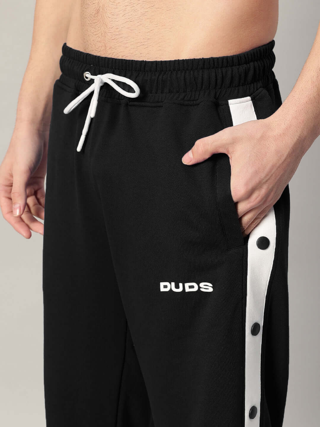 Close-up of DUDS black EZEL relaxed fit jogger with white accents and drawstring, highlighting craftsmanship and style.