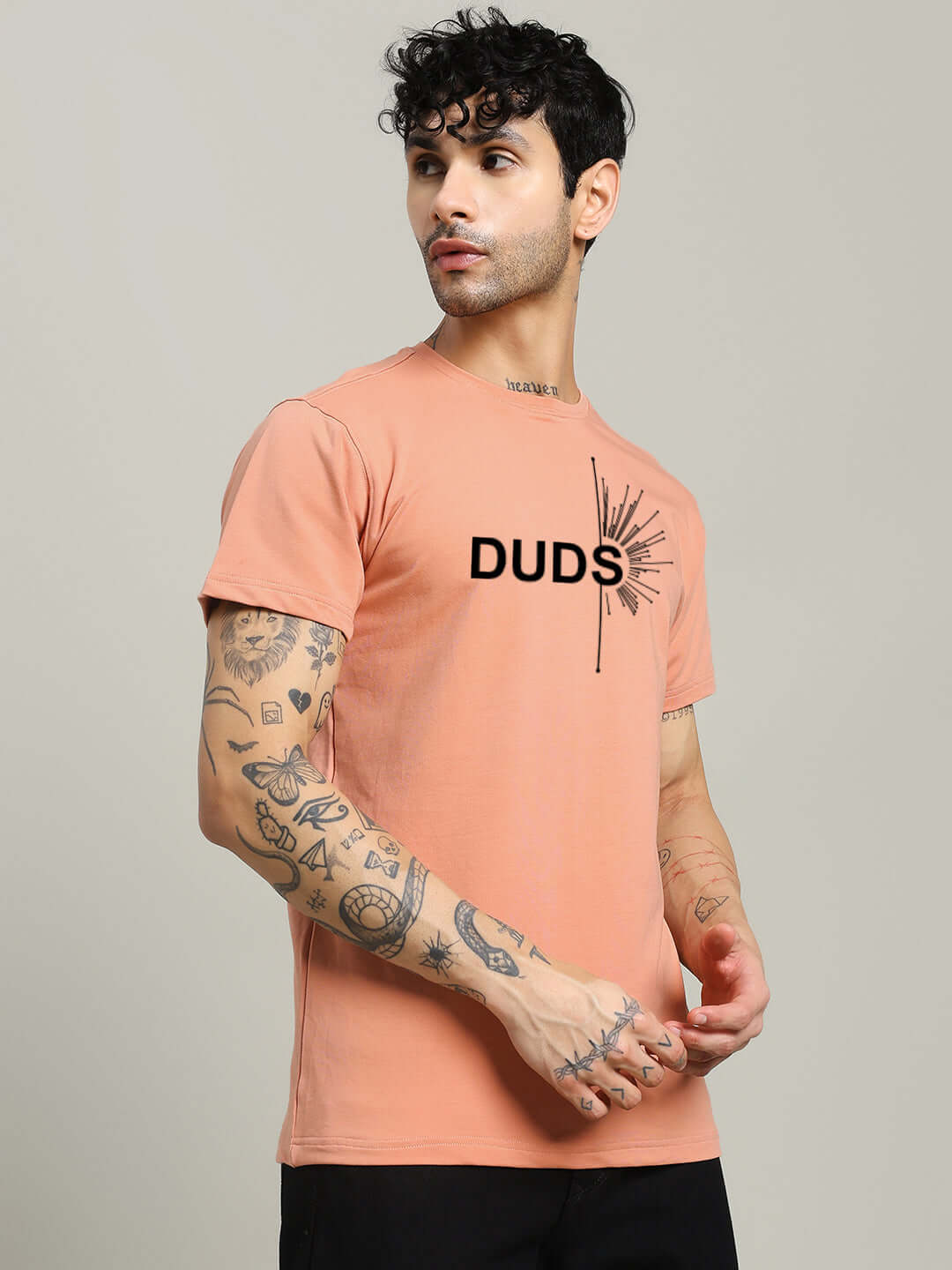 Man wearing peach FALLEN ANGLE regular fit t-shirt with tattooed arms, showcasing premium 100% cotton fabric, by Color By Colours.