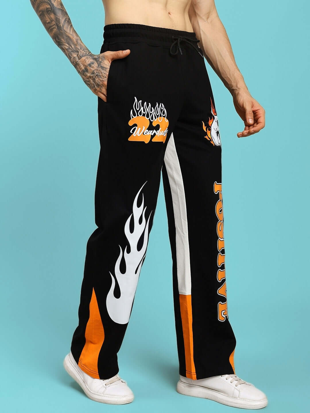 Person wearing FEARLESS CONTRAST POSITIVE RELAXED FIT JOGGERS BLACK-ORANGE with graphic design, made to order by DUDS.