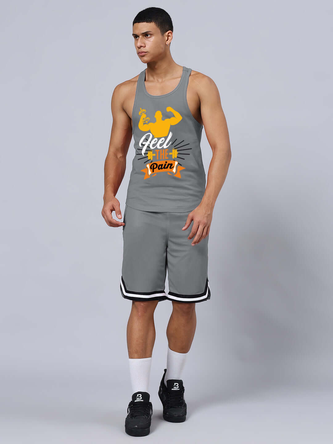 Man wearing FEEL THE PAIN PRINTED GYM T-SHIRT GREY in a studio setting, showcasing gym attire for workouts.