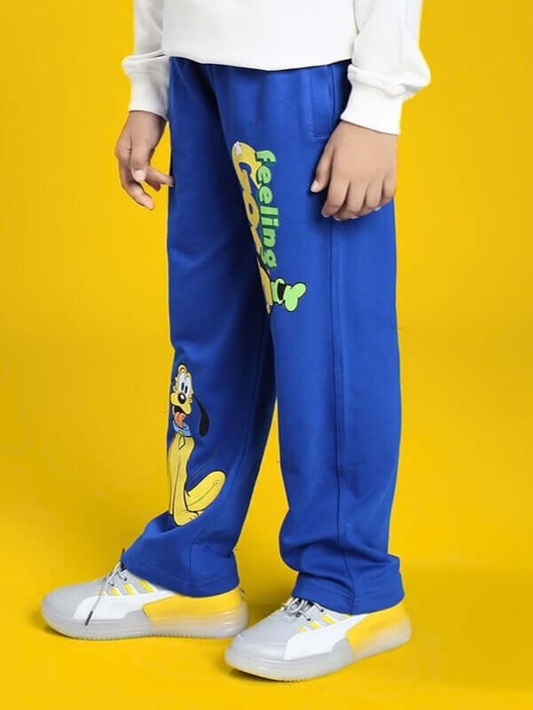 Child wearing FEELING GOOFY JOGGER FOR BOYS AND GIRLS BLUE with colorful cartoon print on yellow background.