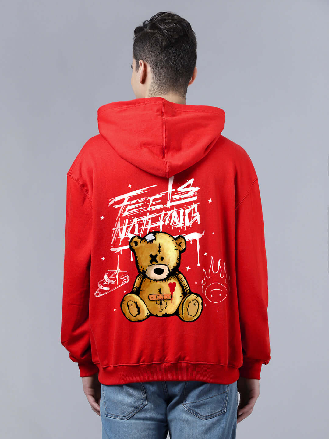 Red oversized hoodie featuring "Feels Nothing" text and teddy bear graphic on the back, casual streetwear fashion.