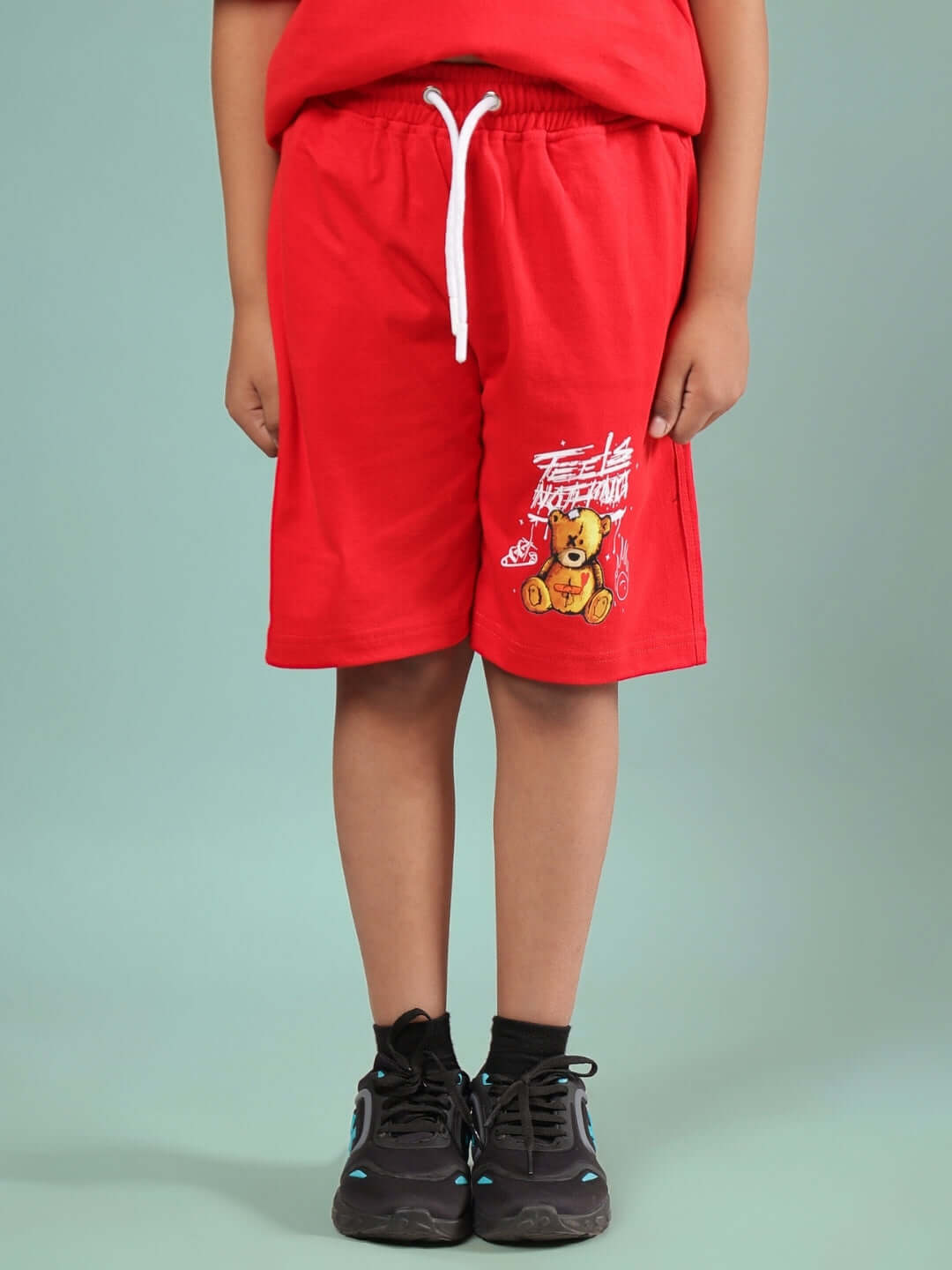 Child wearing FEELS NOTHING SHORTS FOR BOYS & GIRLS RED with graphic print, customizable sizing available.