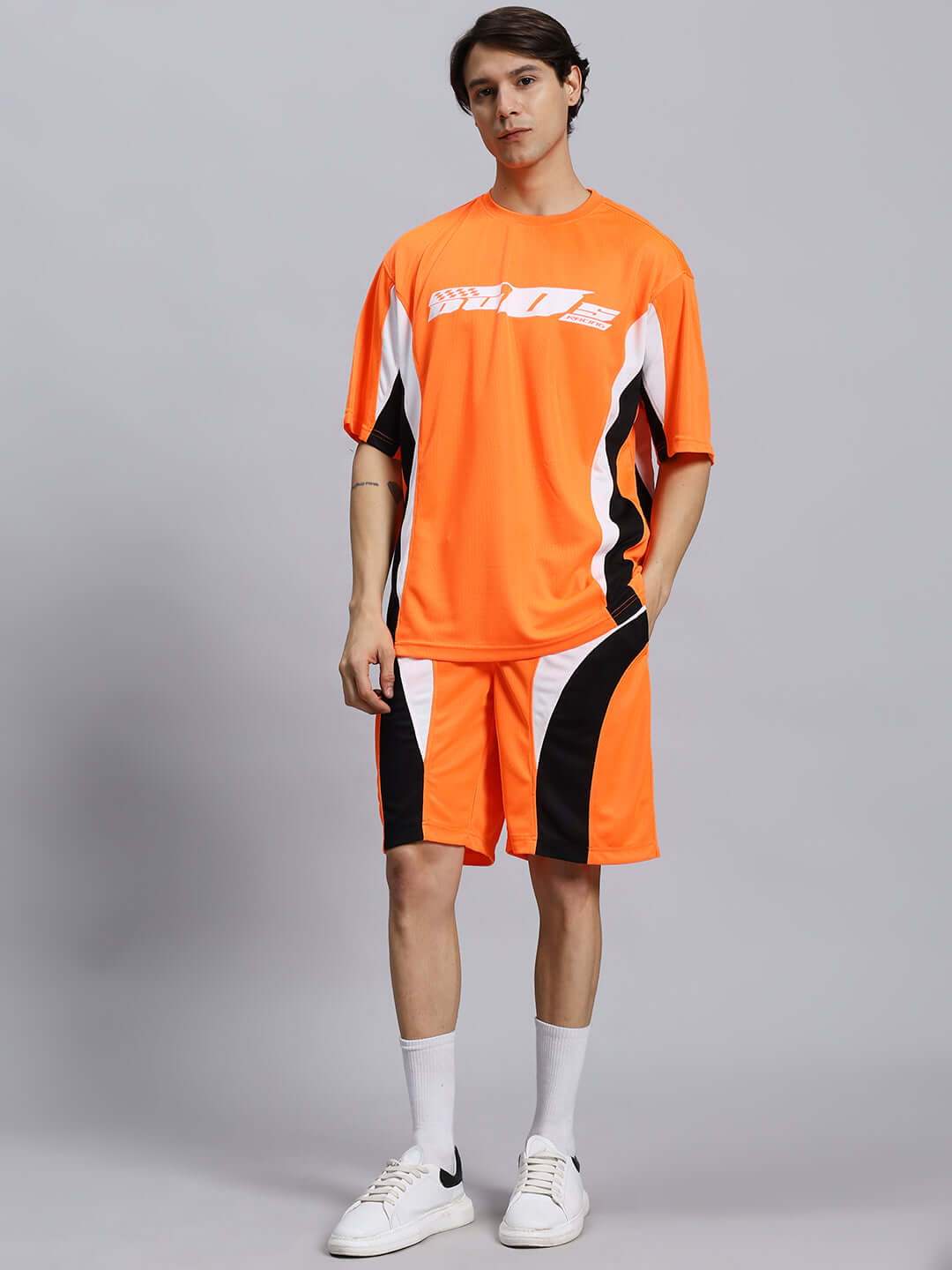 FIFA COLORBLOCK CO-ORD SET ORANGE Person wearing orange FIFA colorblock co-ord set made of sports polyester fabric, showcasing stylish athletic wear.