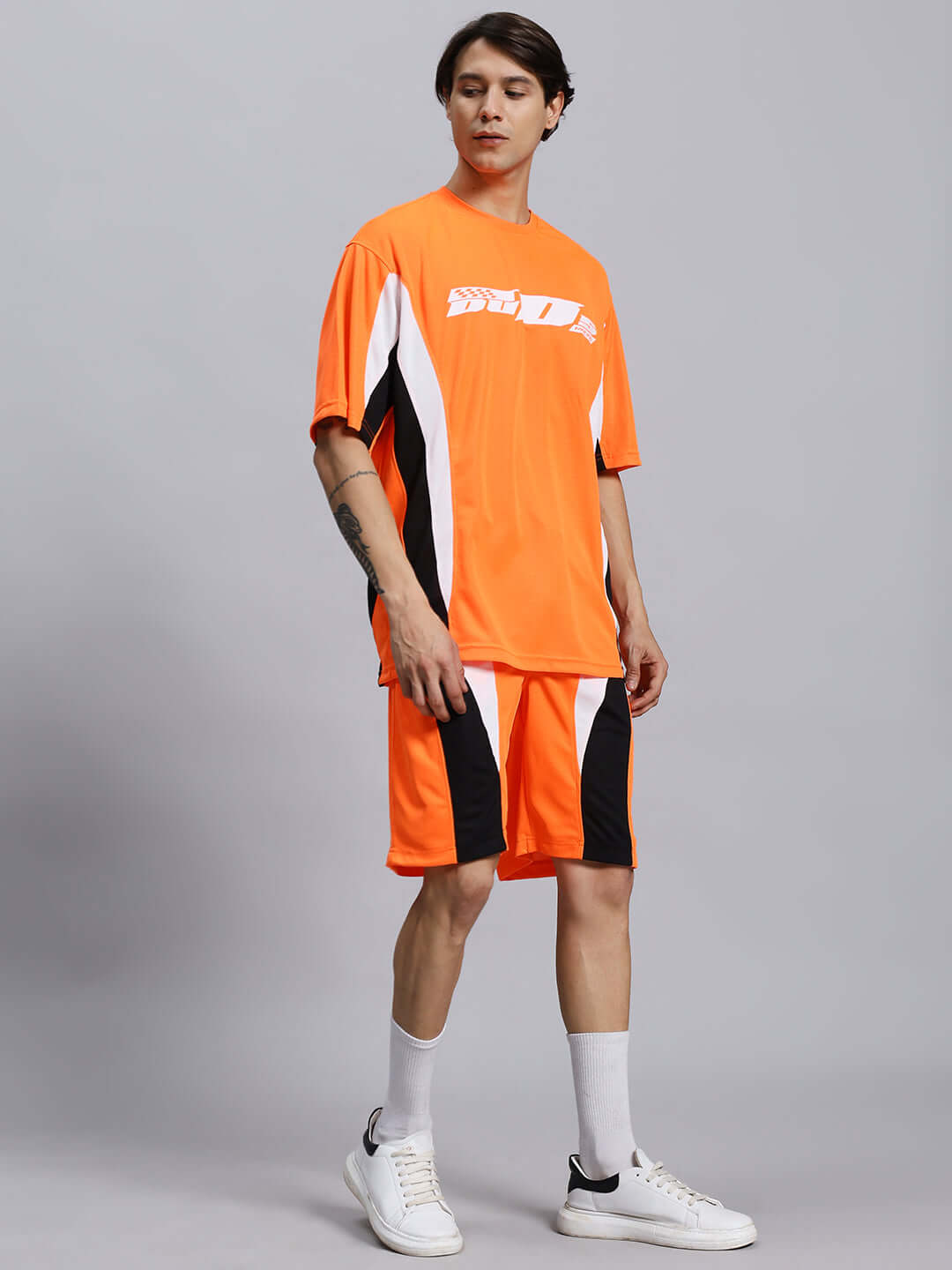 FIFA COLORBLOCK CO-ORD SET ORANGE in vibrant orange, featuring sports polyester fabric. Model wearing set with white sneakers.