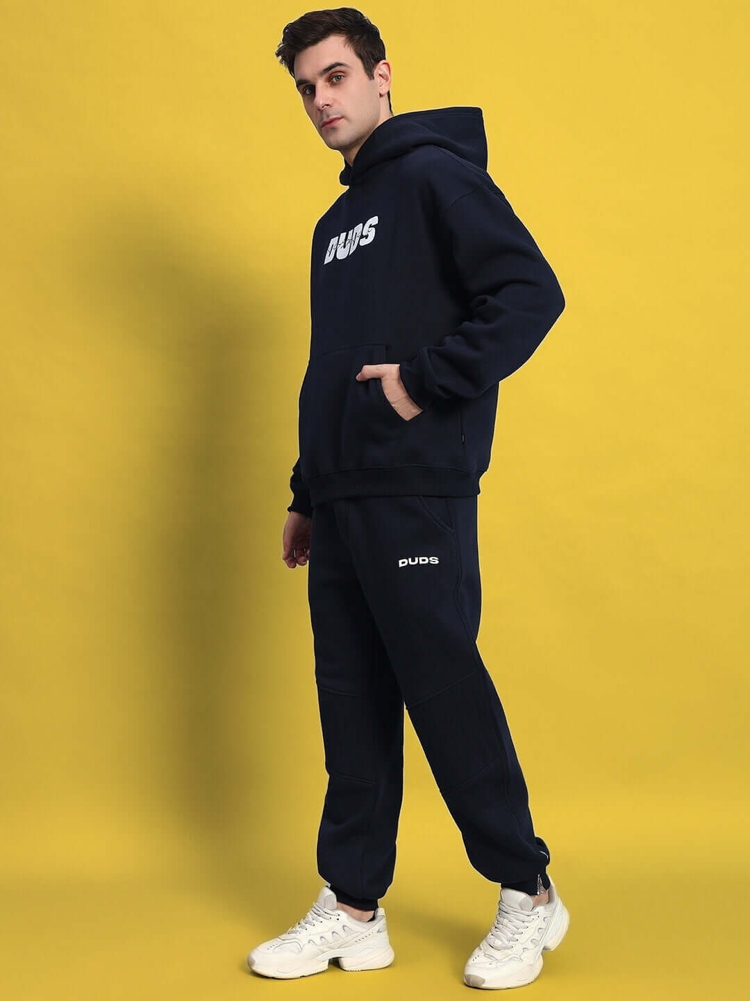 Unisex wearing FIGHT NIGHT FLEECE CO-ORD NAVY BLUE with hoodie and sweatpants, perfect for street style.