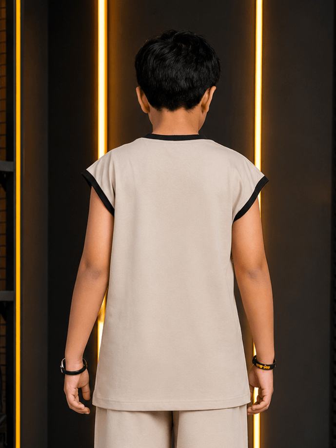 Back view of a child wearing MONO EDGE SLEEVELESS T-SHIRT FOR BOYS GIRLS BEIGE against a modern backdrop.