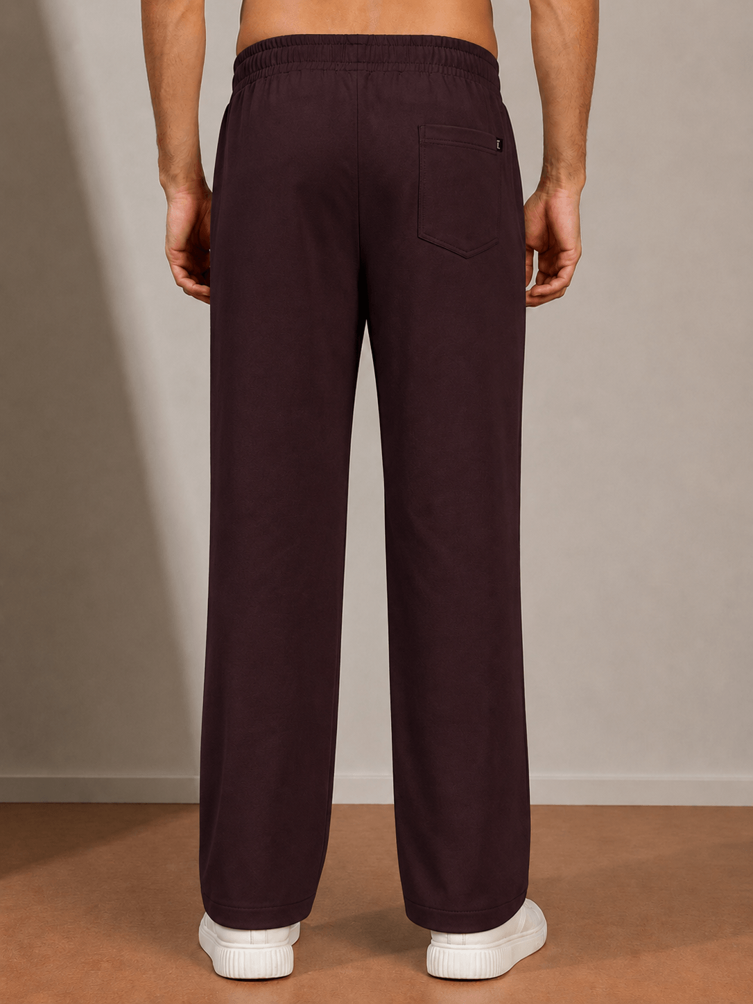 ATHLETIC DRESS TRACK TROUSERS MAROON shown from the back, featuring a relaxed fit and deep maroon color.