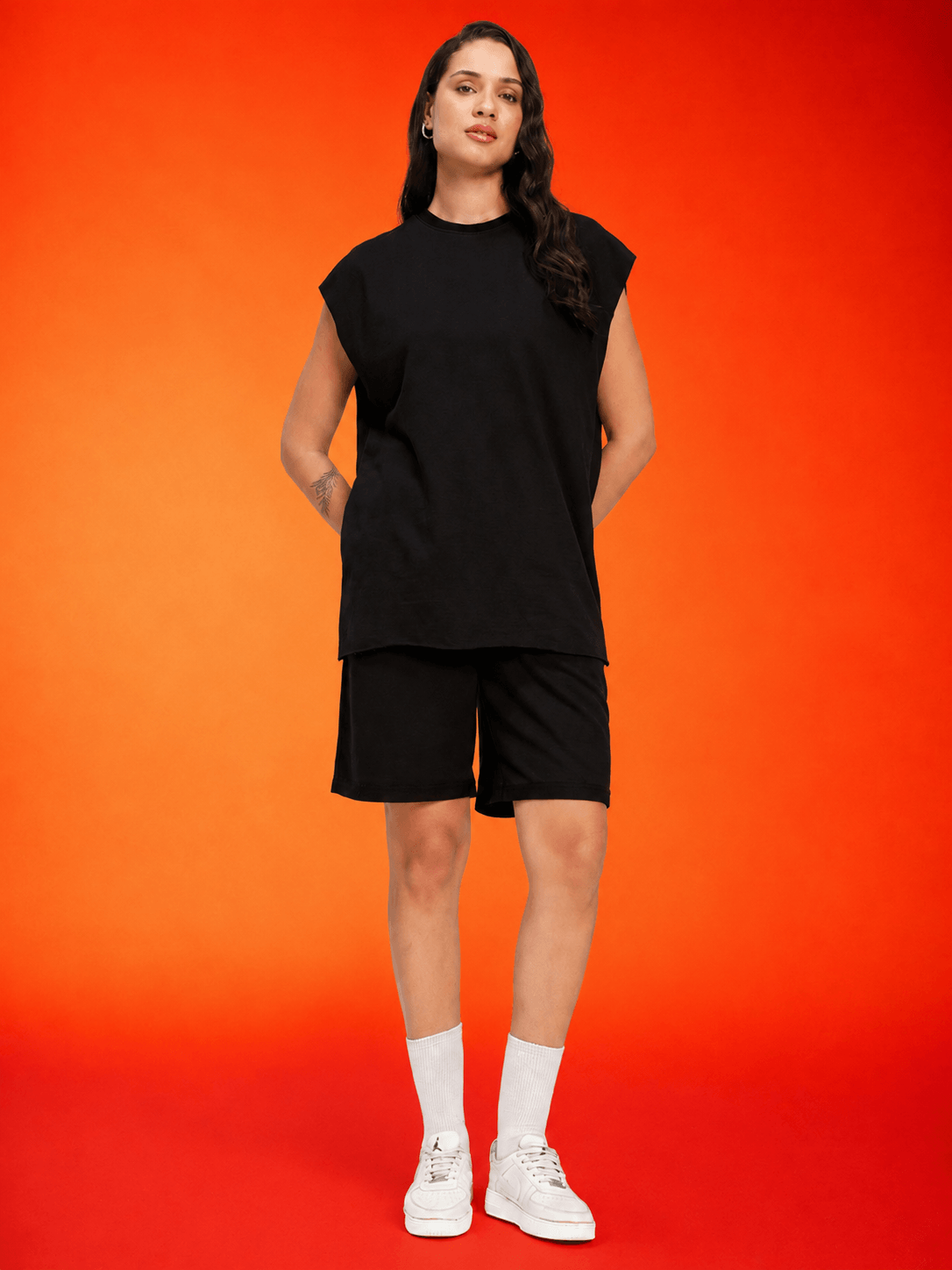 Model wearing WOMEN DRIVE MONOCHROME CO-ORD SET BLACK against a vibrant orange background.
