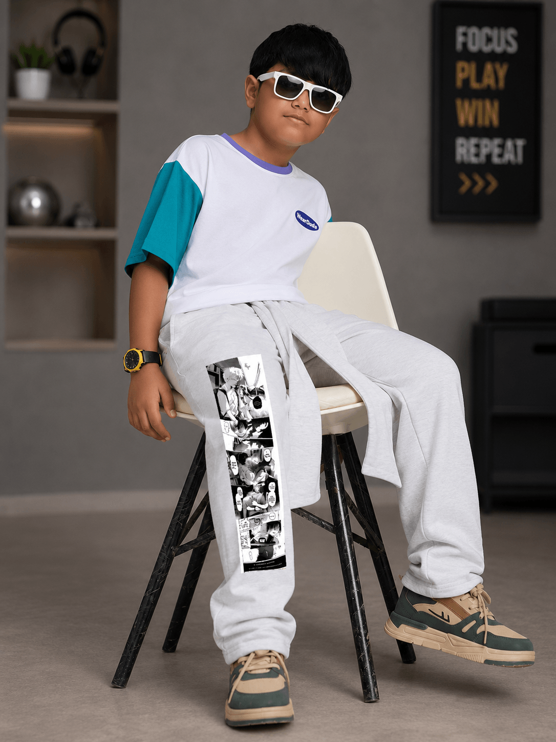 Boy wearing CHILL JOGGER FOR BOYS GIRLS WHITE with a stylish t-shirt and sunglasses, sitting on a chair.