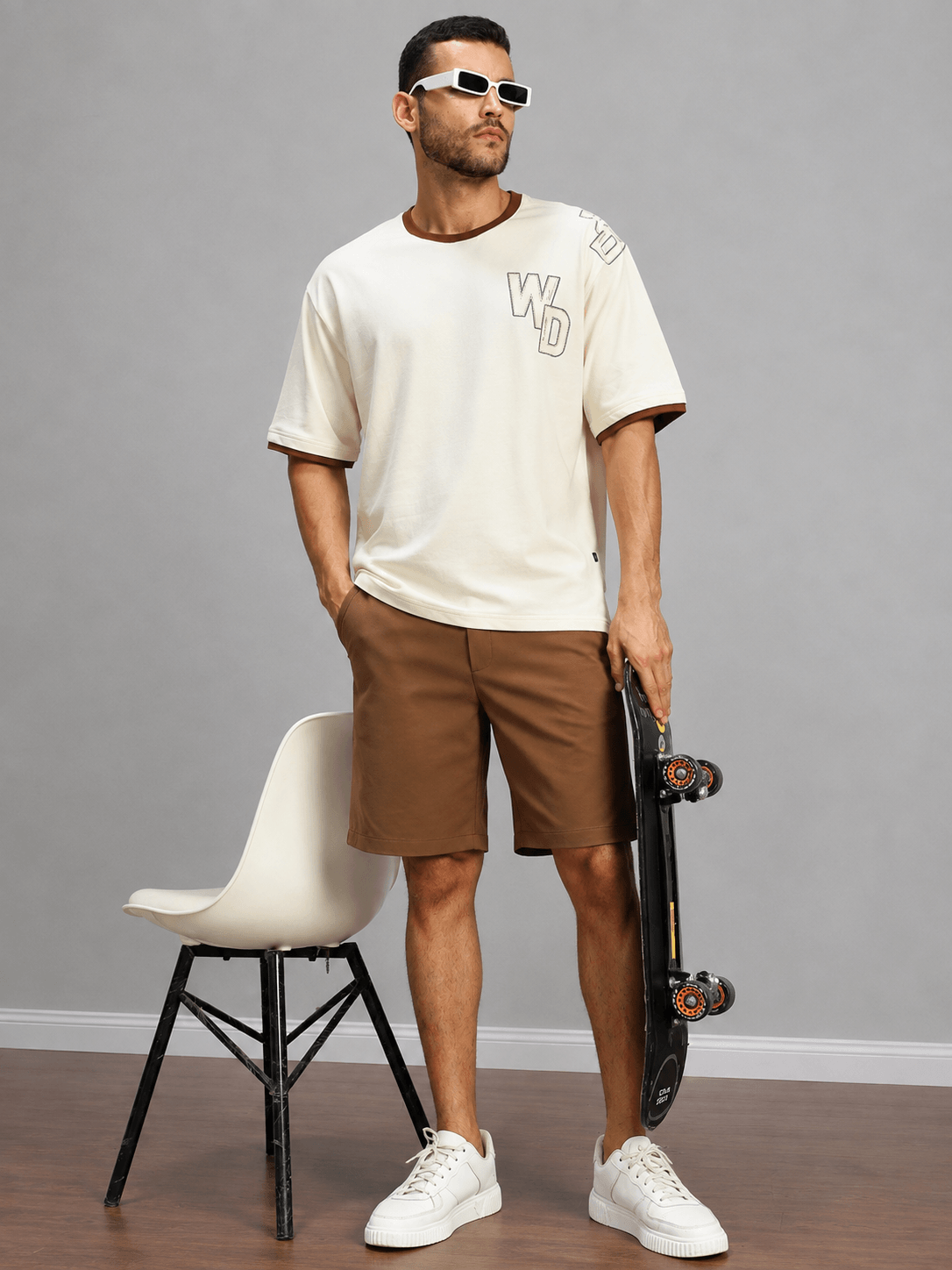 Model wearing SMART CASUAL TOBACCO REGULAR SHORTS BROWN with skateboarding, casual style inspiration.