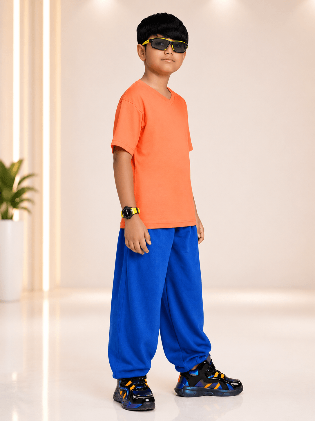 COOLFIT CO-ORD FOR BOYS GIRLS ORANGE BLUE showcased by a boy in orange t-shirt and blue pants, exuding style and comfort.