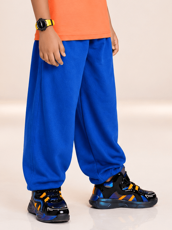 COOLFIT JOGGER FOR BOYS GIRLS BLUE worn by child in vibrant blue joggers and stylish sneakers.