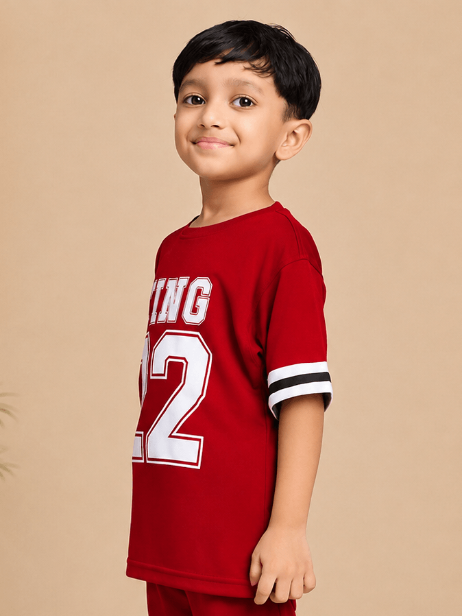 KING 22 VARSITY T-SHIRT FOR BOYS GIRLS RED worn by a smiling boy in a red t-shirt with varsity graphic.