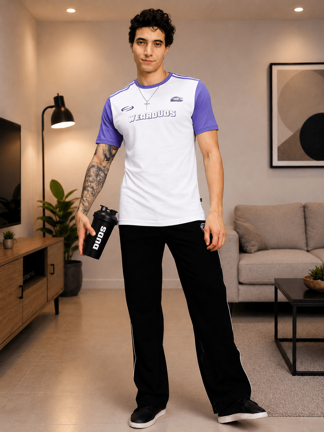 STREET WONDER REGULAR FIT T-SHIRT WHITE MULTI worn by a man holding a water bottle in a modern living room.
