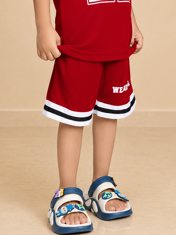 KING 22 VARSITY COOL SHORTS FOR BOYS GIRLS RED worn by a child with sporty sandals, showcasing bold athletic style.