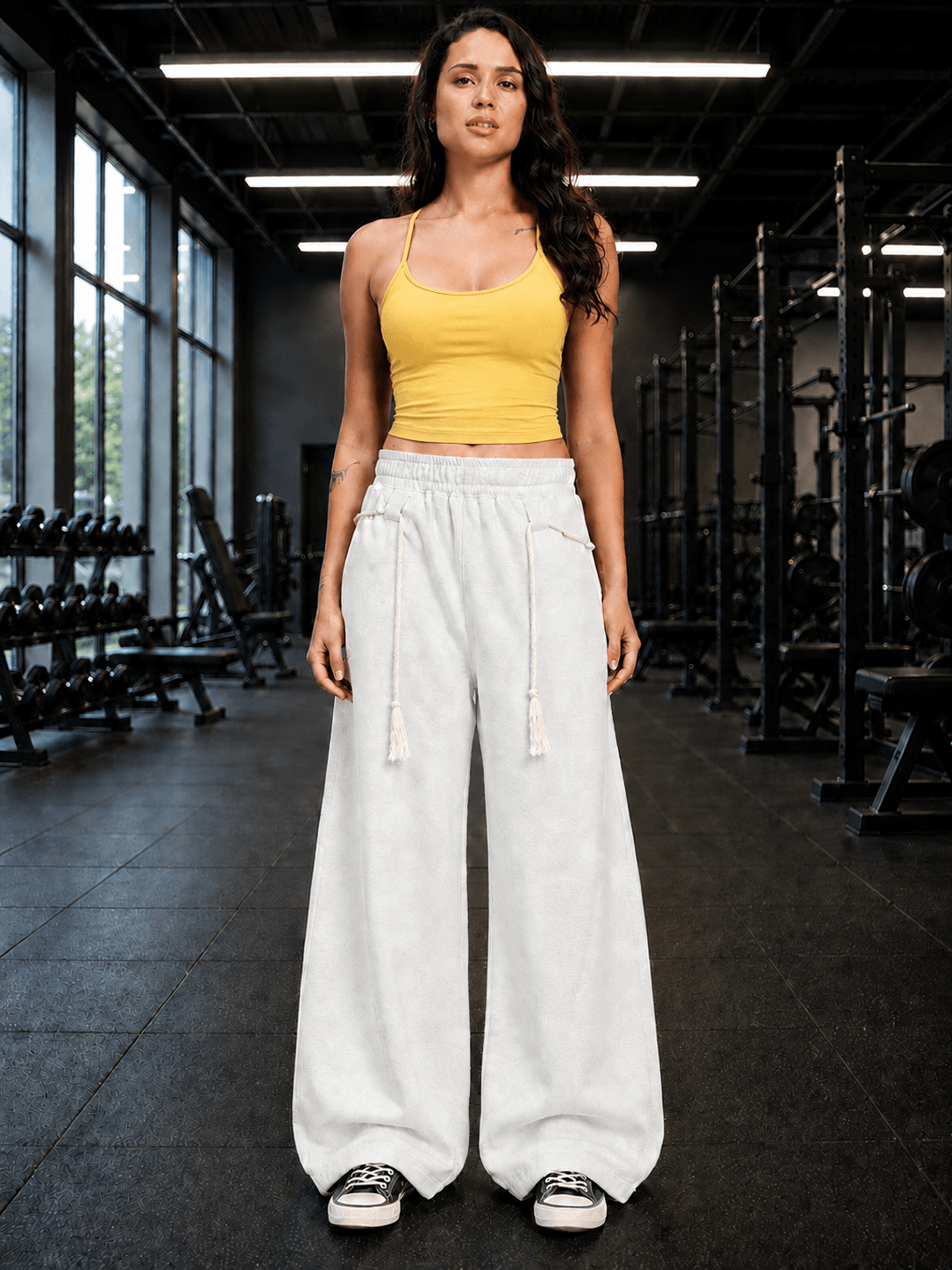WOMEN SEAMLESS COTTON CROP-TOP YELLOW worn with white wide-leg pants in a gym setting.