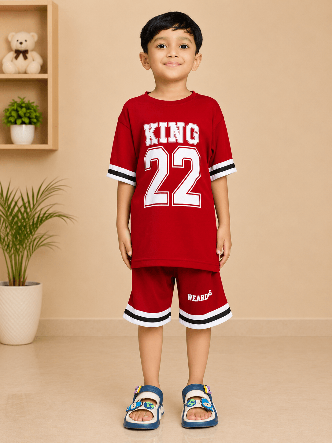KING 22 VARSITY CO-ORD SET FOR BOYS GIRLS RED worn by a boy standing confidently in a stylish indoor setting.