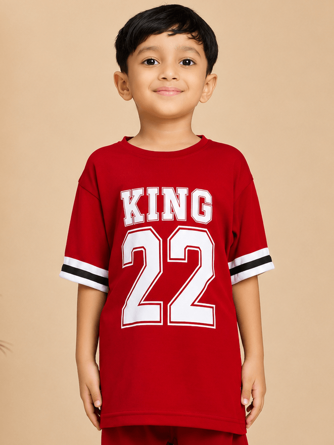 KING 22 VARSITY T-SHIRT FOR BOYS GIRLS RED worn by a boy smiling, showcasing its vibrant color and stylish design.