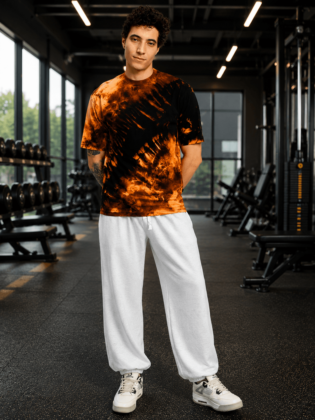 Model wearing COOLFIT BAGGY LOOSE FIT JOGGER WHITE with a stylish tie-dye shirt in a gym setting.