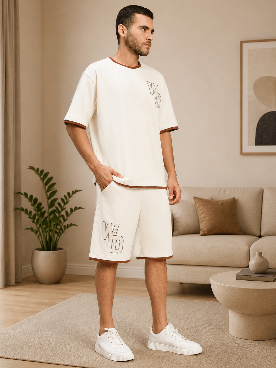 DOWNTOWN RELAXED FIT CO-ORD SET WHITE worn by a model in a modern living room setting.