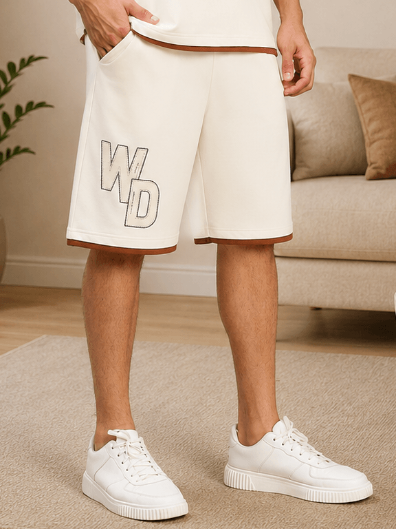 DOWNTOWN RELAXED FIT SHORTS WHITE displayed on a model with white sneakers in a cozy indoor setting.