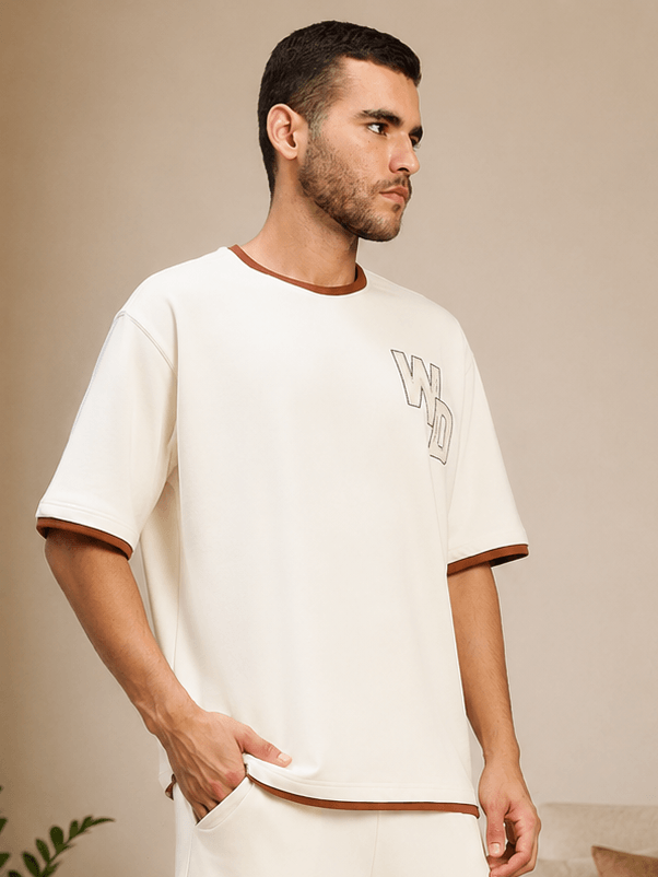 DOWNTOWN RELAXED FIT T-SHIRT WHITE modeled by a man in a minimalist setting, showcasing its relaxed style.