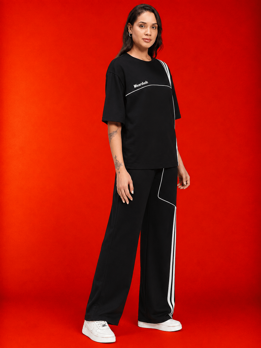 Women Youth Contrest Piping T-Shirt Black worn by a model on a red background, showcasing sporty style and contrasting piping.