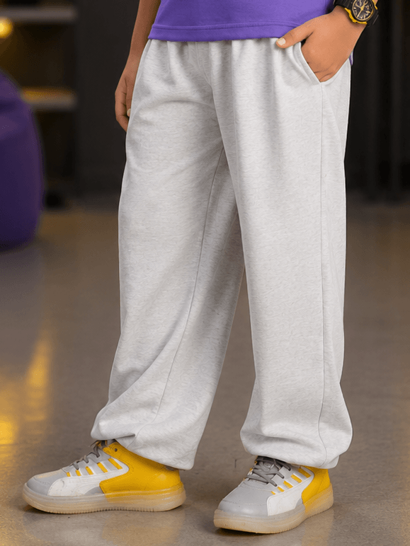 COOLFIT JOGGER FOR BOYS GIRLS WHITE modeled by a kid wearing soft gray joggers and stylish sneakers.