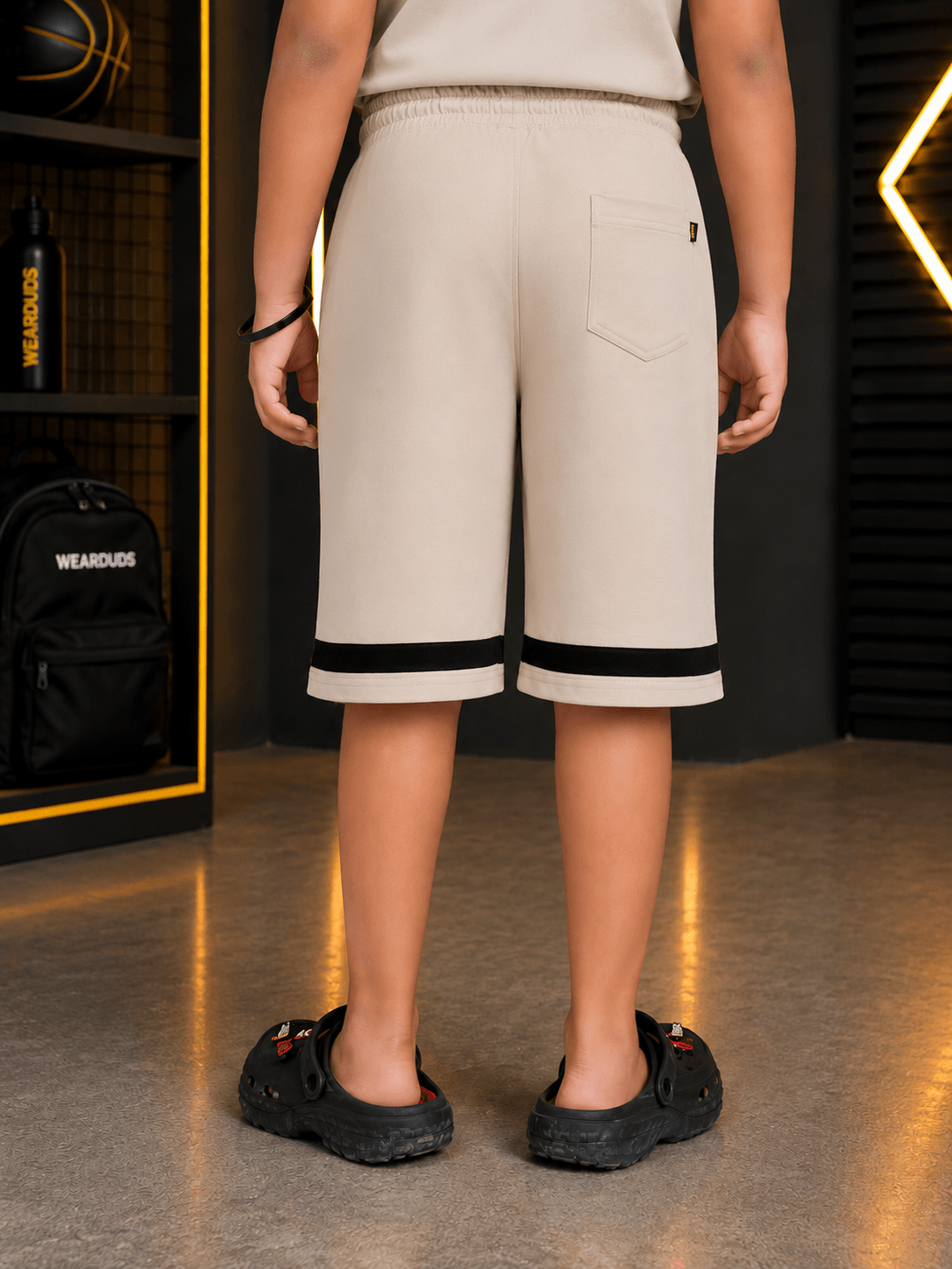 MONO EDGE SLEEVELESS CO-ORD FOR BOYS GIRLS BEIGE shown from the back, featuring beige shorts with black stripes.