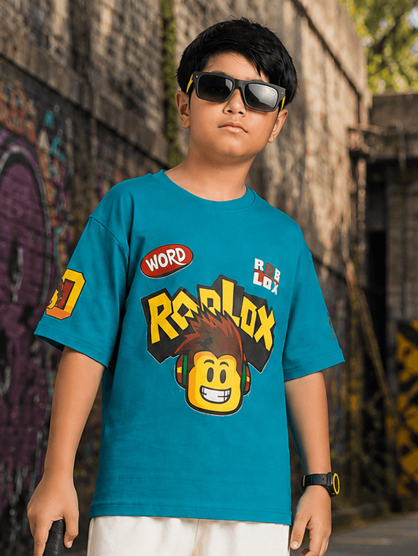 JUNIOR T-SHIRT FOR BOYS GIRLS BLUE worn by a boy with sunglasses, featuring a Roblox graphic design.