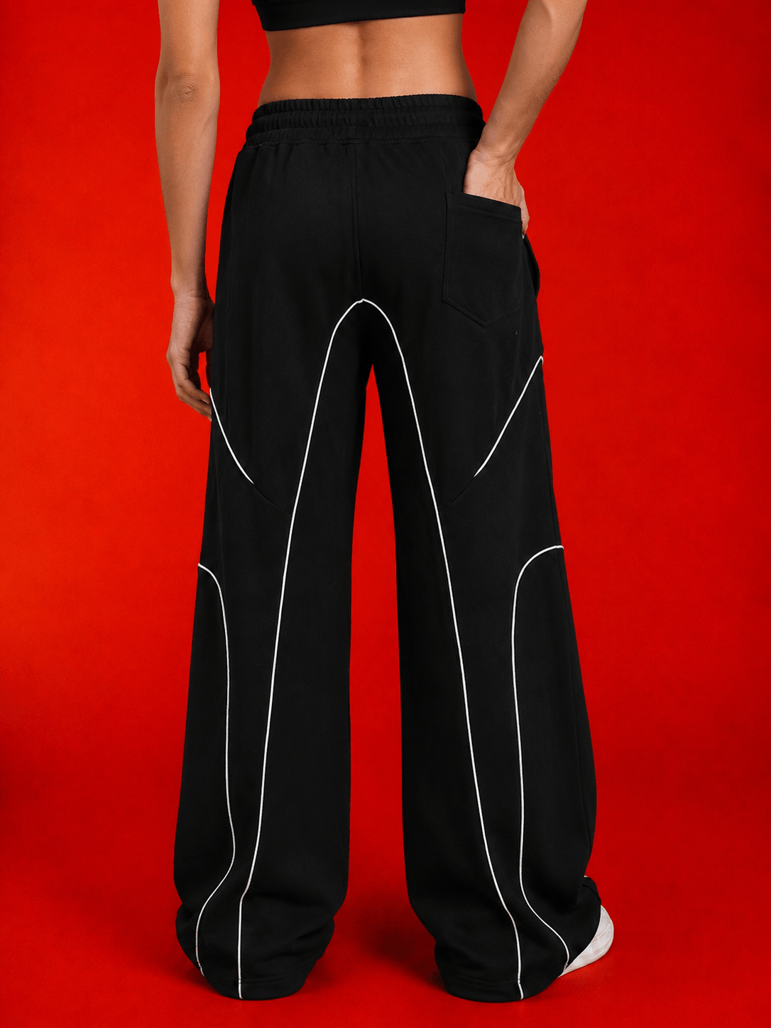 Back view of WOMEN SIGNATURE PIPING JOGGERS BLACK showcasing contrast piping and relaxed fit.