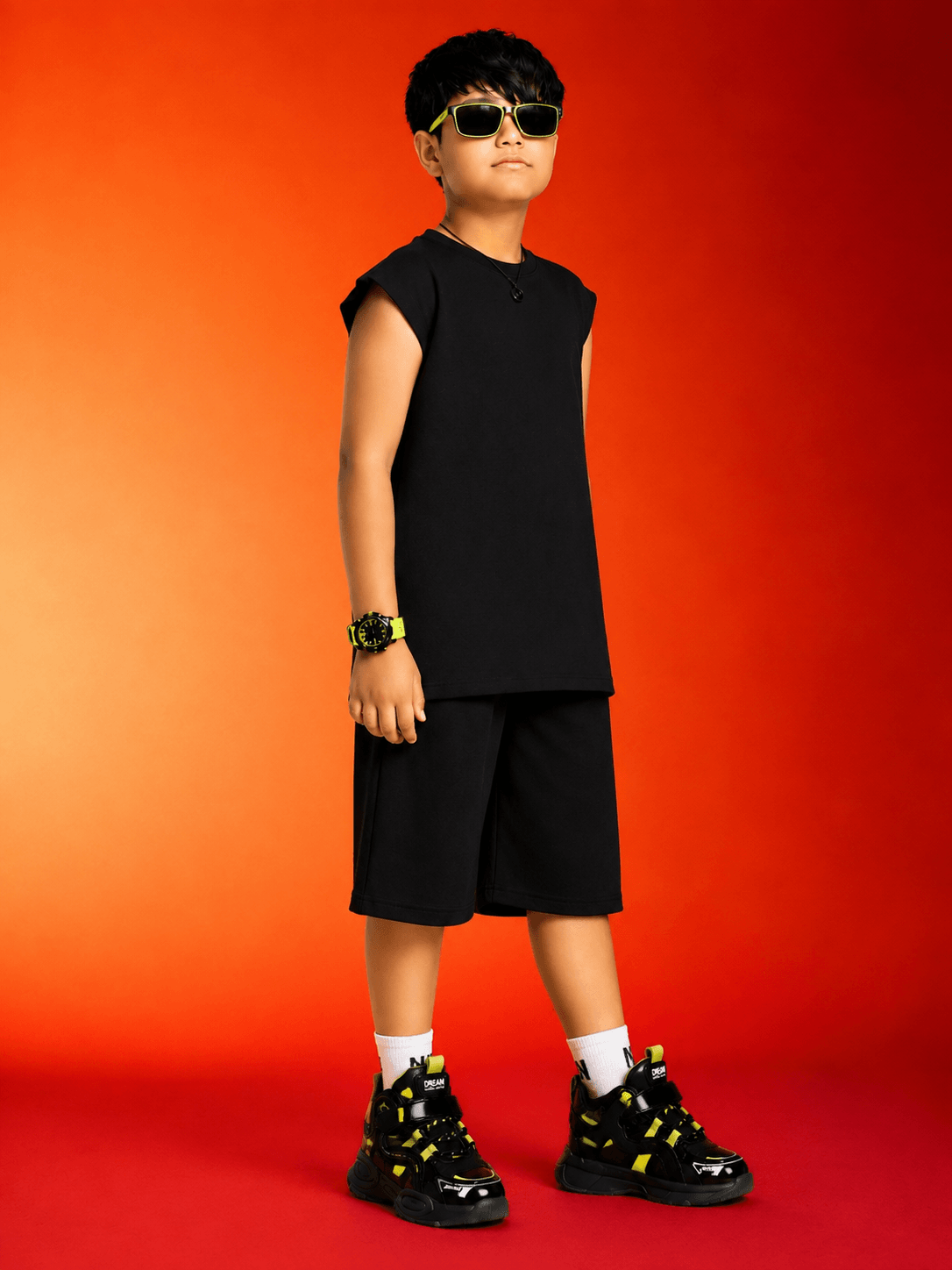 NEON RUSH SLEEVELESS CO-ORD FOR BOYS GIRLS BLACK showcased by a confident boy in black athletic wear.