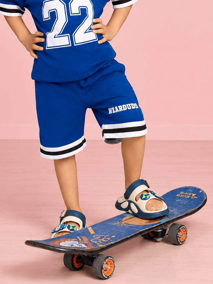 KING 22 VARSITY COOL SHORTS FOR BOYS GIRLS BLUE worn by a child on a skateboard, showcasing sporty style.
