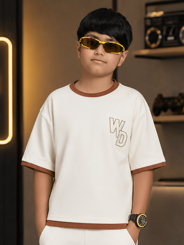 DOWNTOWN T-SHIRT FOR BOYS & GIRLS OFF-WHITE modeled by a boy wearing yellow sunglasses in a modern setting.