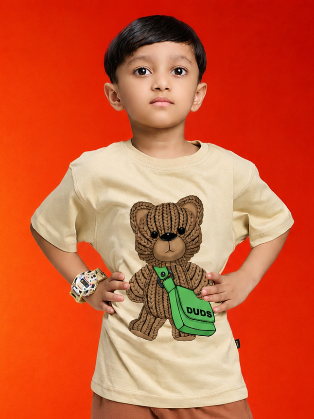 LITTLE EXPLORER TEDDY T-SHIRT FOR BOYS GIRLS BEIGE worn by a boy posing confidently with a cute teddy graphic.