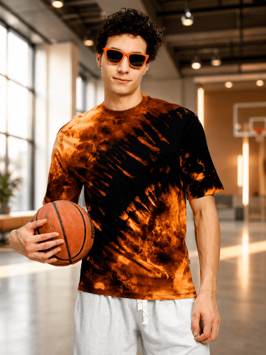 SOLAR TIE-DYE T-SHIRT BLACK FIRE ORANGE worn by a model in a basketball court setting.