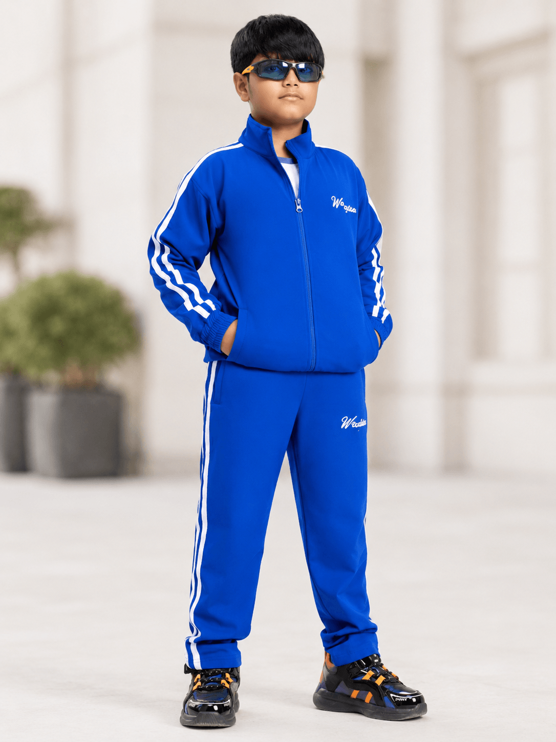 SPORTY ZIP UP CO-ORD SET FOR BOYS AND GIRLS ROYAL BLUE worn by a stylish boy in sunglasses.