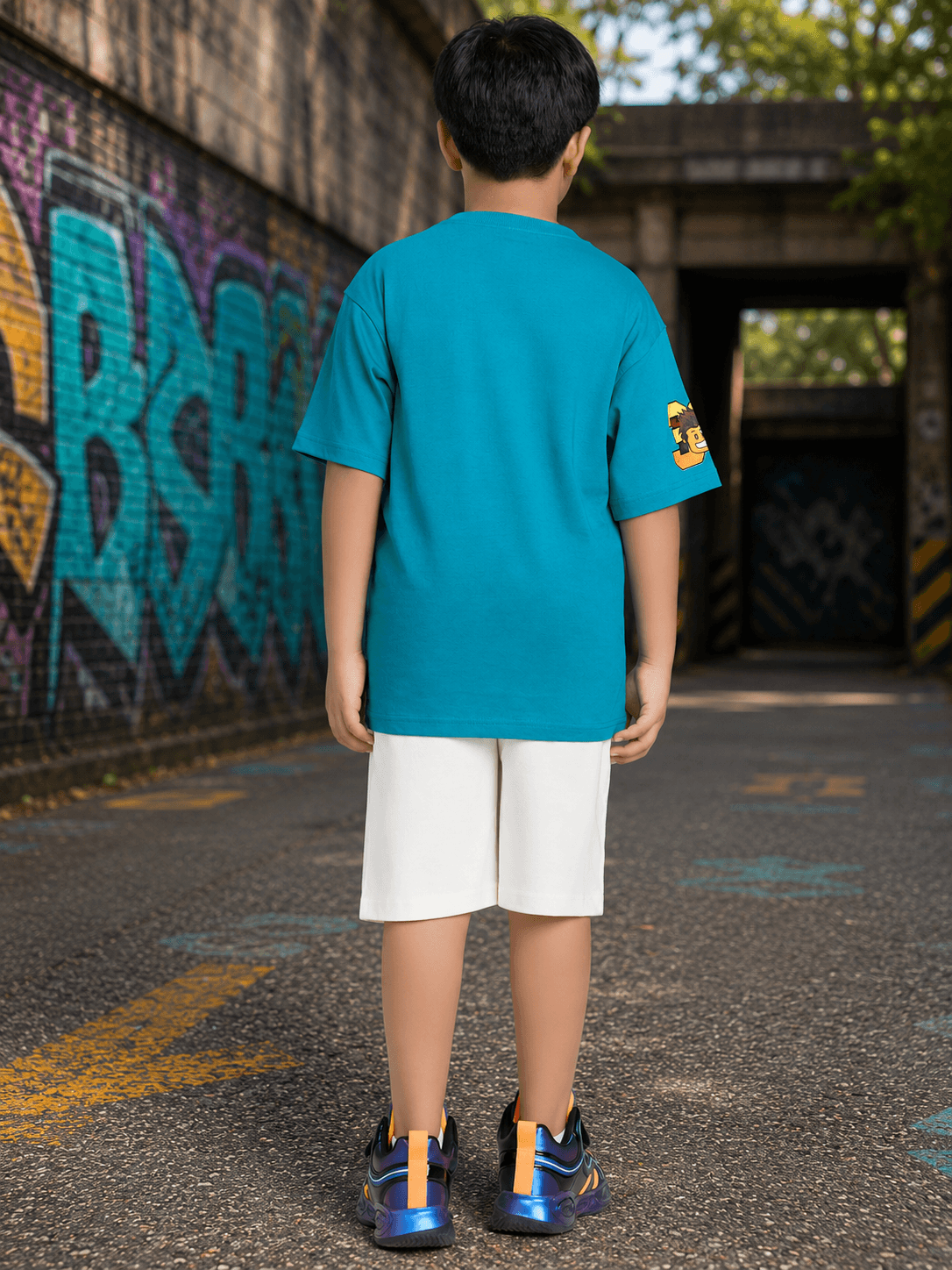 JUNIOR CO-ORD FOR BOYS GIRLS BLUE WHITE outfit for kids featuring blue t-shirt and white shorts in urban setting.