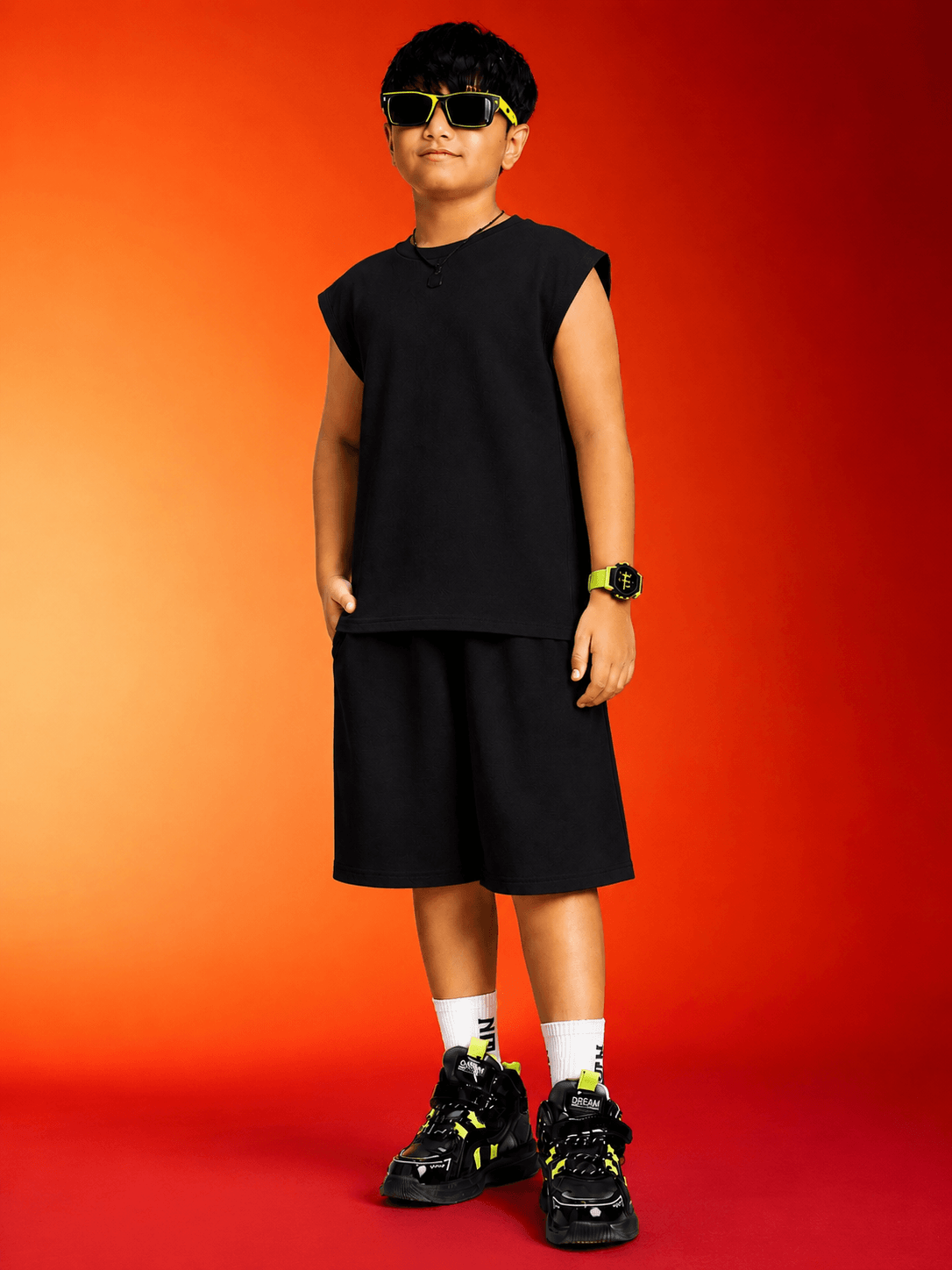 NEON RUSH SLEEVELESS T-SHIRT FOR BOYS GIRLS BLACK worn by a boy in sporty activewear with sunglasses.