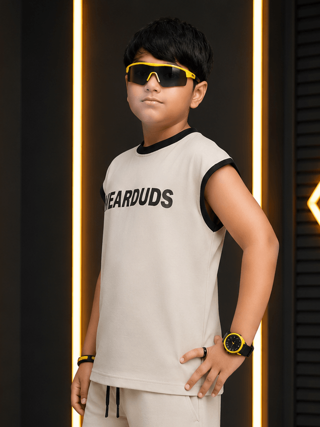 MONO EDGE SLEEVELESS T-SHIRT FOR BOYS GIRLS BEIGE worn by a boy with sunglasses in a trendy setting.