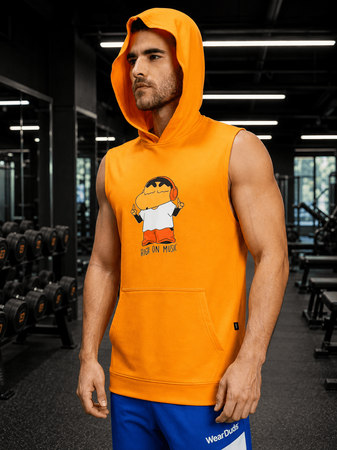 BEAT MODE SLEEVELESS HOODED T-SHIRT WHITE ORANGE worn by a model in a gym setting, showcasing its vibrant design.