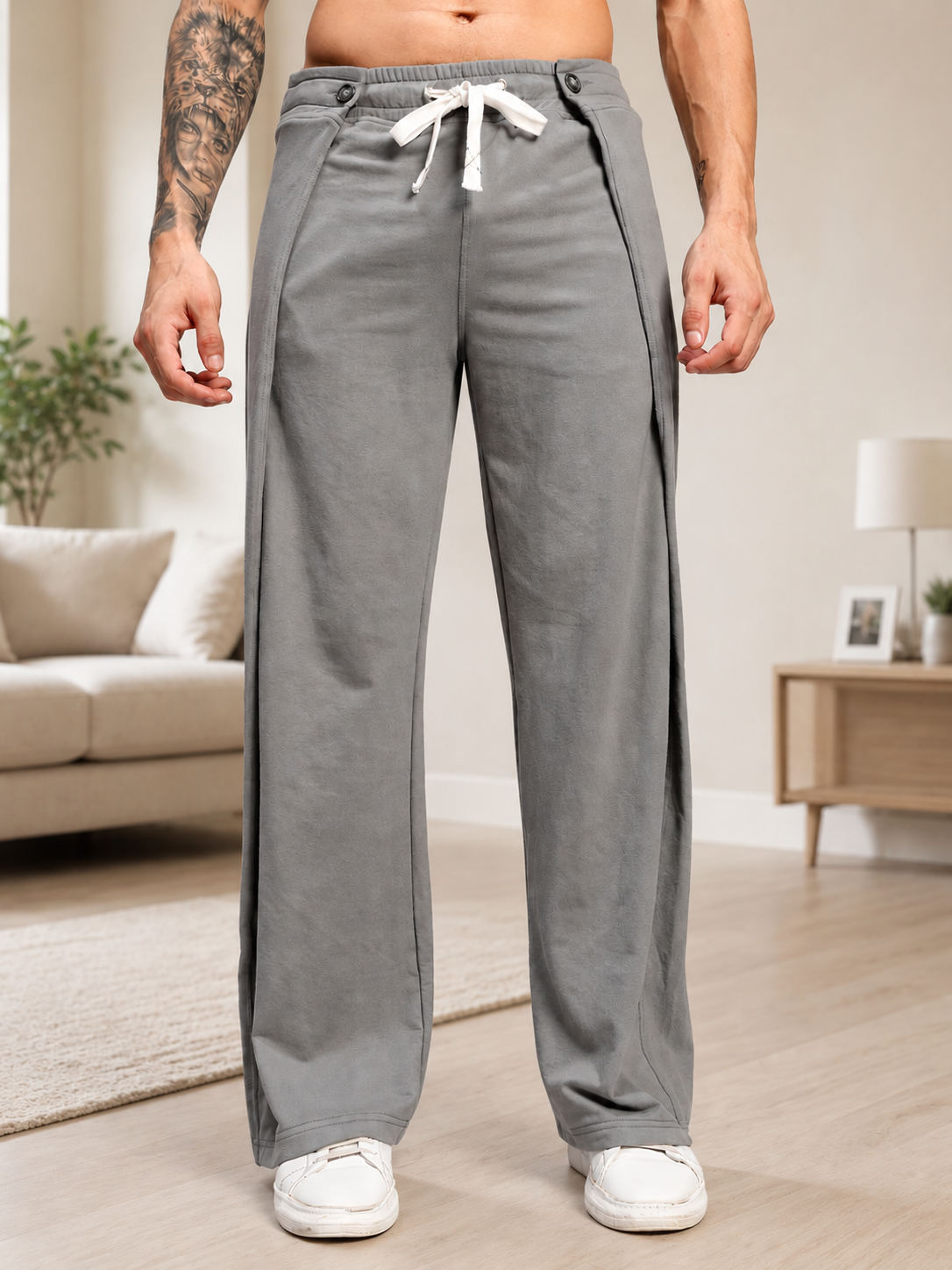OMEGA FLOW WIDE FIT JOGGERS GREY displayed on a man in a modern living room setting.