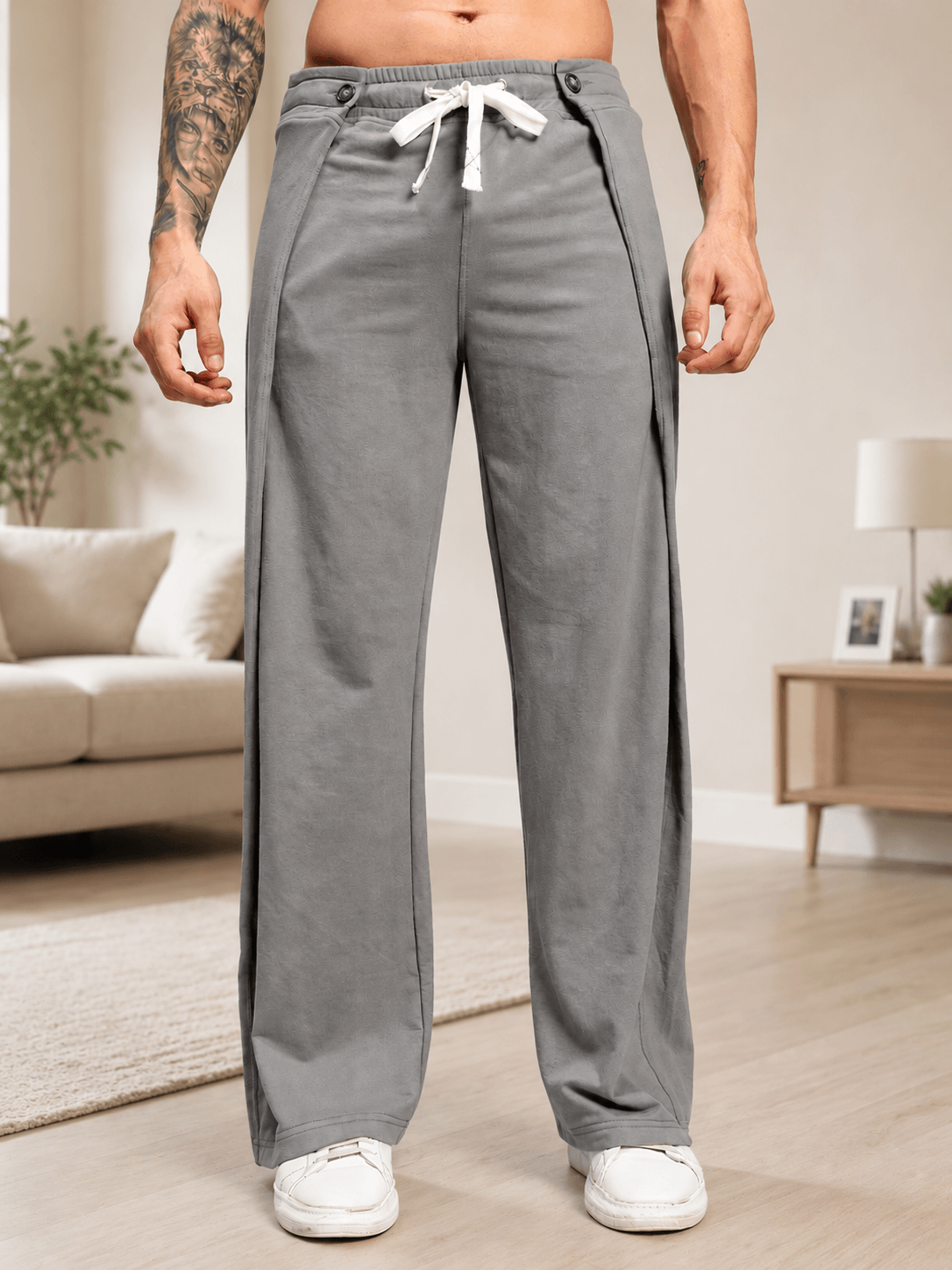OMEGA FLOW WIDE FIT JOGGERS GREY displayed on a man in a modern living room setting.