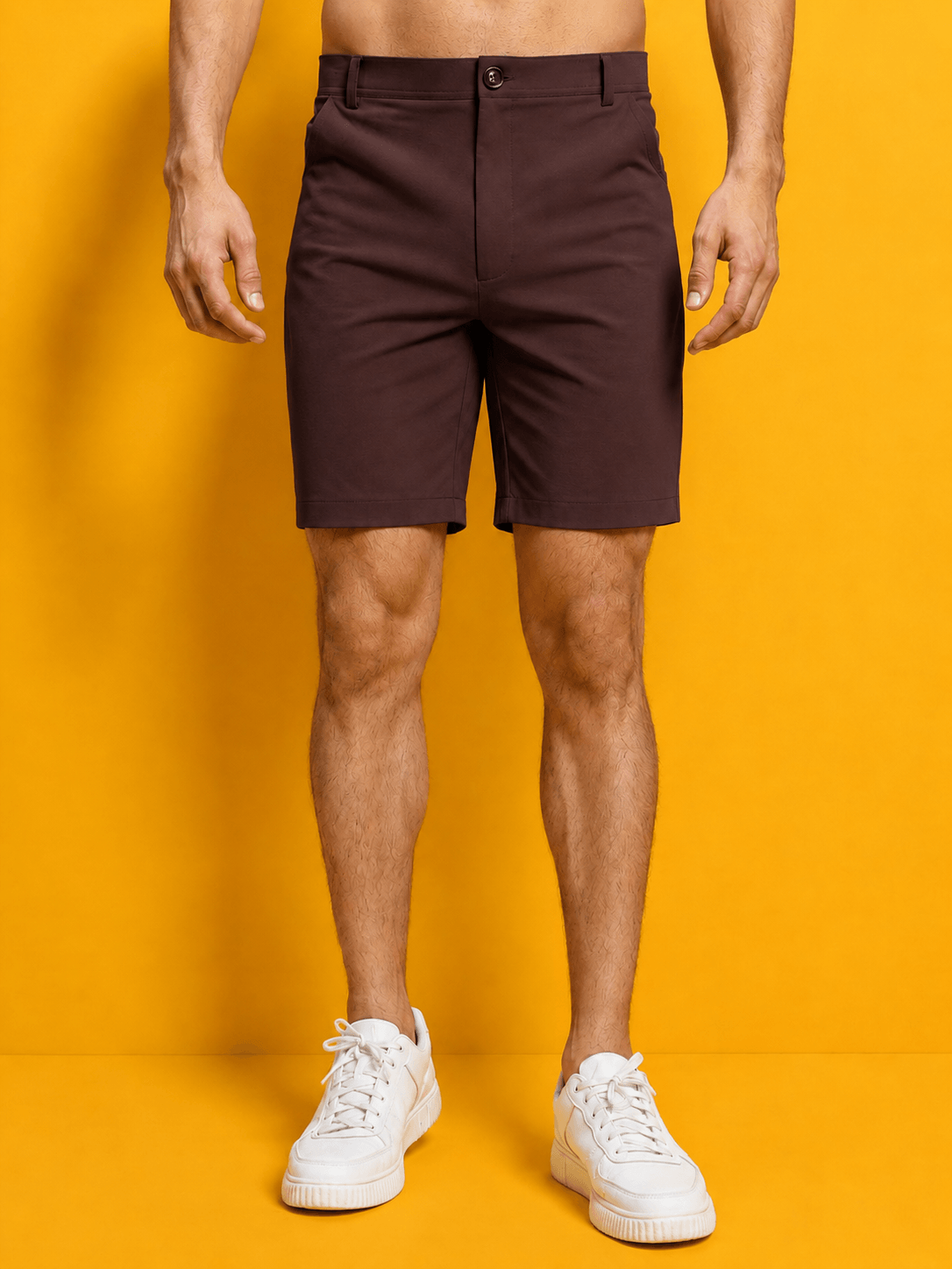 PRIME FIT PERFORMANCE REGULAR SHORTS MAROON model wearing maroon shorts with a yellow background.