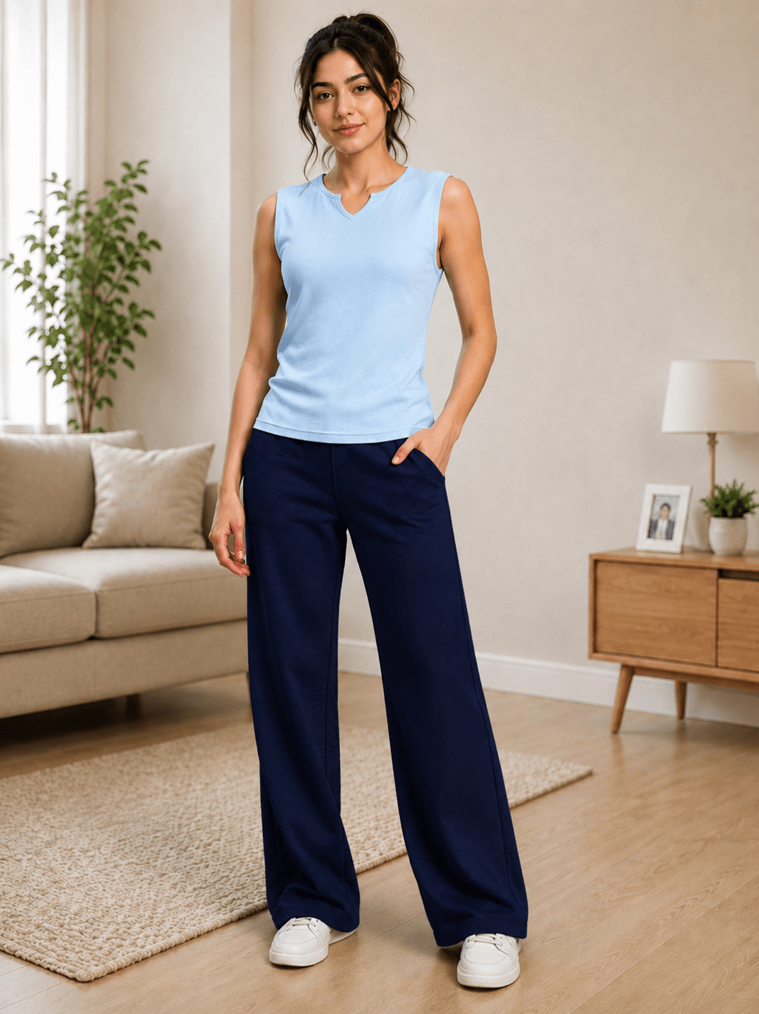 WOMEN OMEGA FLOW WIDE FIT JOGGERS BLUE paired with a light blue top in a modern living room setting.