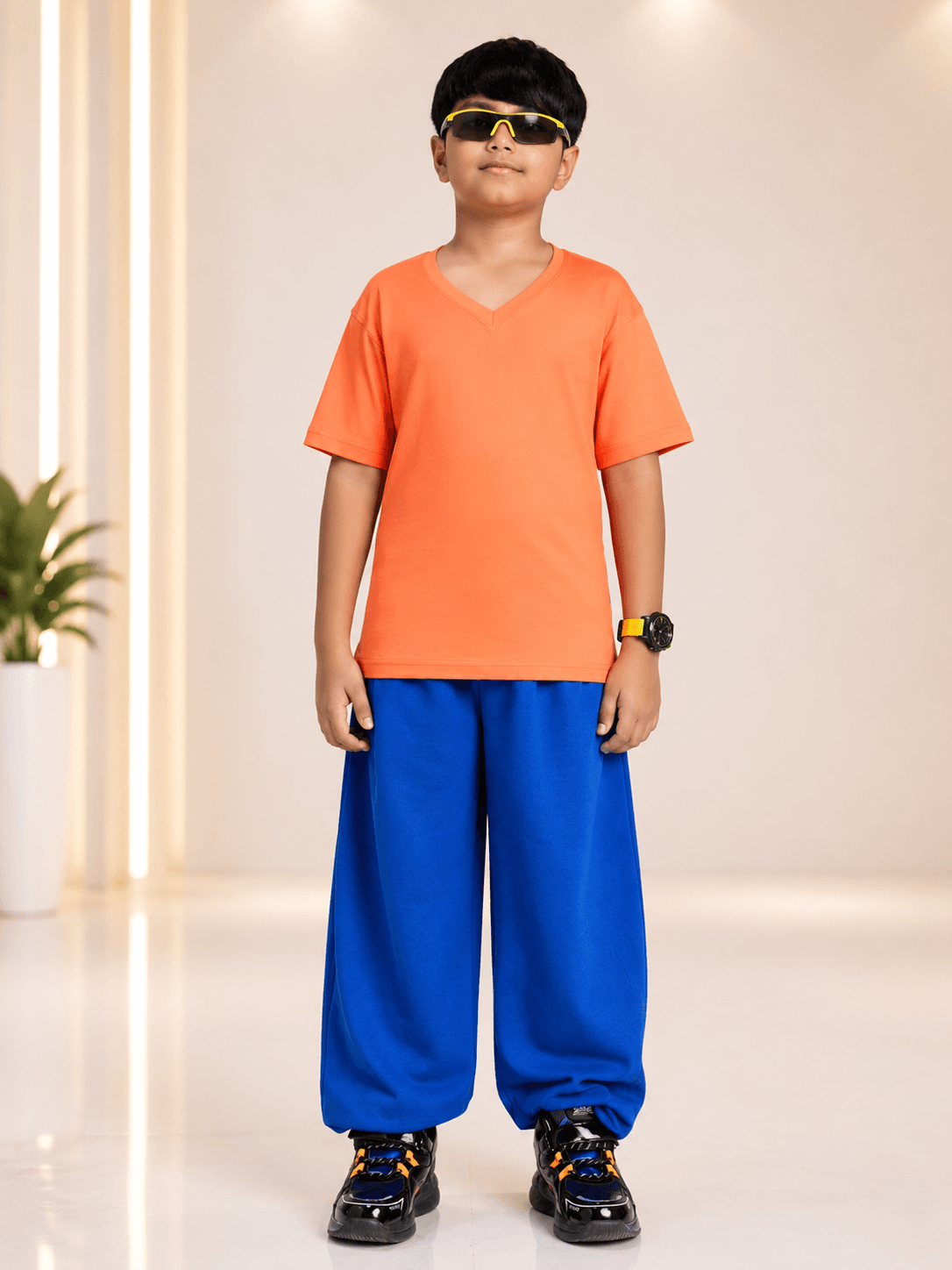 COOLFIT JOGGER FOR BOYS GIRLS BLUE showcased on a stylish boy wearing an orange shirt and blue joggers.