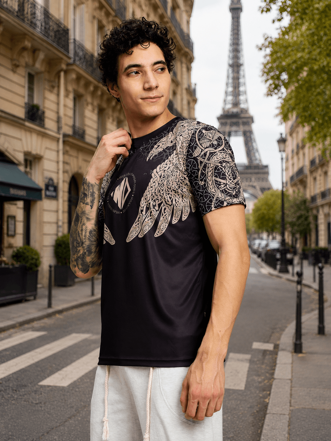 AURA OF ASGARD REGULAR T-SHIRT BLACK worn by a model in front of the Eiffel Tower, showcasing its stylish design and casual fit.
