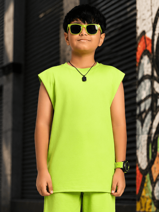 NEON RUSH SLEEVELESS T-SHIRT FOR BOYS GIRLS NEON GREEN on a boy wearing sunglasses and accessories in a vibrant setting.
