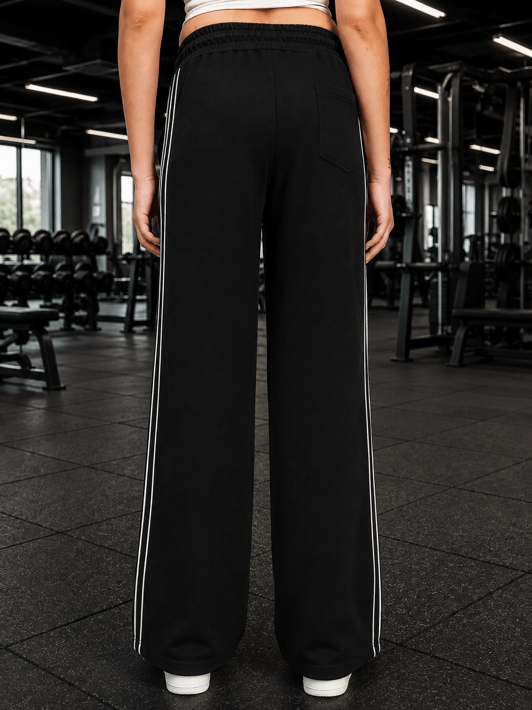 Women Black Out-Fit Wide Leg Joggers Black shown from the back in a gym setting, highlighting the stylish wide-leg design.